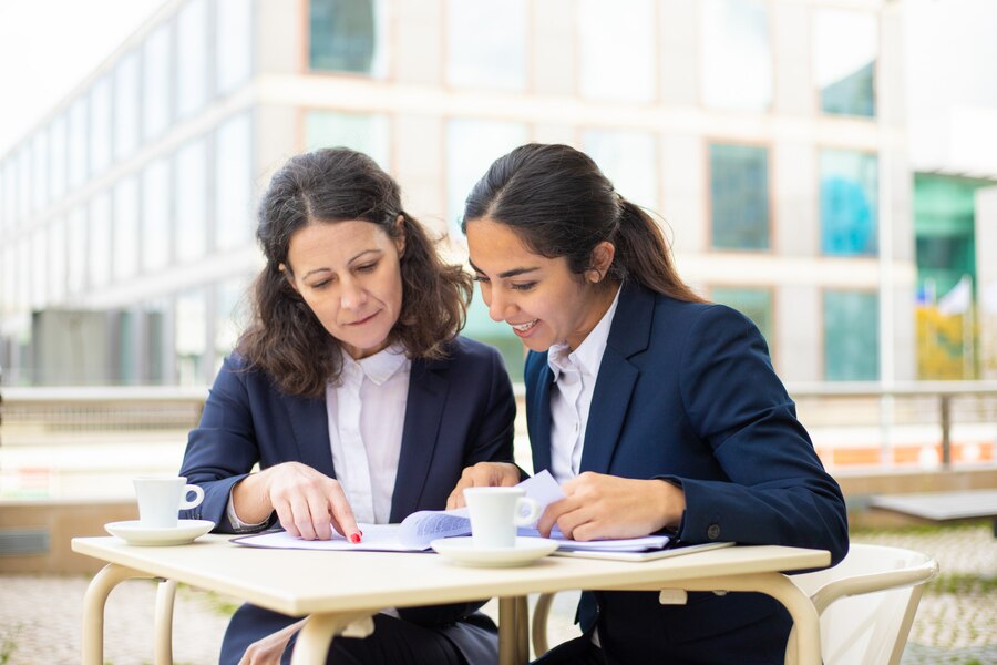 businesswomen-working-with-documents-outdoor-cafe_74855-4974
