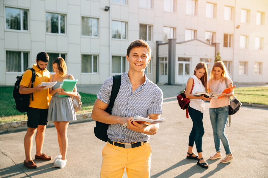 happy-student-with-note-books-backpack-smiling-while-standing_8353-6388